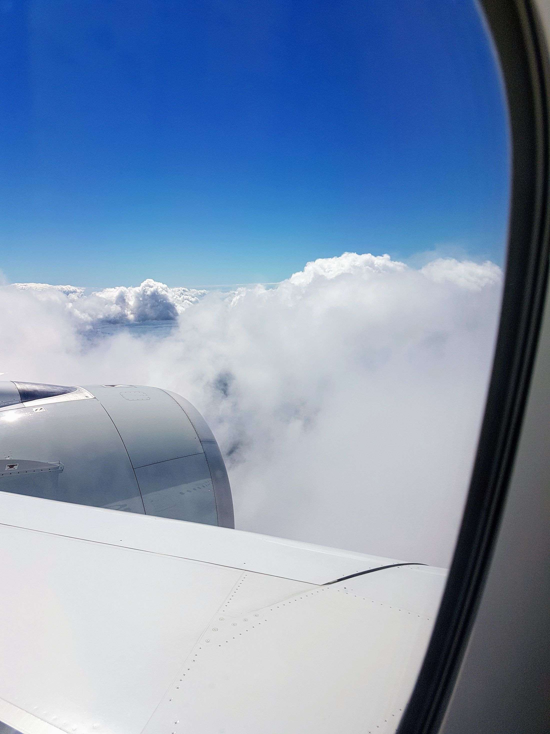 Blick aus dem Flugzeugfenster über den Wolken